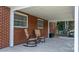 Covered brick patio with rocking chairs offering a cozy and inviting outdoor space at 2623 Ne 13Th Ne St, Hickory, NC 28601