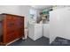 Bright laundry room featuring a washer, dryer, storage cabinet, and a convenient folding area at 2623 Ne 13Th Ne St, Hickory, NC 28601