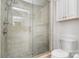 Bathroom featuring a glass shower with pebble floor, white cabinets, and neutral wall tile at 2825 Sharon View Rd, Charlotte, NC 28210