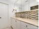 Bathroom with a large mirror, custom tile backsplash, a light-colored countertop, and white cabinets at 2825 Sharon View Rd, Charlotte, NC 28210