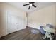 Bedroom with large closet, small blue chair, dark wood floor and ceiling fan at 333 Anne Ave, Waxhaw, NC 28173