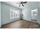 Bright bedroom with white trim, a window with shutter blinds, dark floors, and a door to the bathroom at 333 Anne Ave, Waxhaw, NC 28173