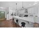 Modern kitchen features a large island with a white countertop, pendant lighting, white cabinetry, and stainless steel appliances at 333 Anne Ave, Waxhaw, NC 28173