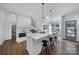 Modern white kitchen featuring stainless steel appliances, an island with bar seating, and bright lighting, perfect for entertaining at 333 Anne Ave, Waxhaw, NC 28173