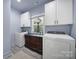 Well-organized laundry room with modern appliances and decorative cabinet between washer and dryer at 333 Anne Ave, Waxhaw, NC 28173