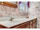Bathroom featuring a double vanity, floral wallpaper, and natural lighting at 36433 Azalea Cir, New London, NC 28127