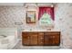 Bathroom featuring a double vanity, floral wallpaper, and natural lighting at 36433 Azalea Cir, New London, NC 28127