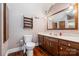 Bright bathroom featuring a wooden shelf, hanging mirror, and wood flooring at 36433 Azalea Cir, New London, NC 28127