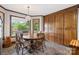 Cozy dining area with wood table, chairs, and storage cabinets, illuminated by a hanging light fixture and natural light at 36433 Azalea Cir, New London, NC 28127
