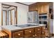 Kitchen island with cooktop, stainless steel refrigerator, and double ovens at 36433 Azalea Cir, New London, NC 28127