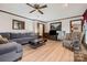 Comfortable living room featuring an accent wall, plush furniture, and a ceiling fan for added comfort at 36433 Azalea Cir, New London, NC 28127