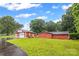 Two large, red outbuildings sit on a verdant lawn behind the house, great for storage or workshop at 36433 Azalea Cir, New London, NC 28127