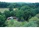 An aerial view of the property with barns and lush, mature trees at 4171 Leatherman Rd, Vale, NC 28168