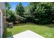 A lush backyard features green grass, a concrete patio, and mature trees at 437 Danielle Way, Fort Mill, SC 29715