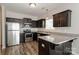 Modern kitchen with stainless steel appliances, dark cabinets, granite countertops, and wood flooring at 437 Danielle Way, Fort Mill, SC 29715