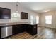 Modern kitchen with stainless steel appliances, dark cabinets, granite countertops, and wood flooring at 437 Danielle Way, Fort Mill, SC 29715