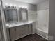 Bathroom featuring double sink vanity and tub with tile surround at 5855 Amity Springs Dr, Charlotte, NC 28212