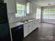 Well-lit kitchen with white cabinets, granite countertops, stainless steel sink, and modern appliances at 5855 Amity Springs Dr, Charlotte, NC 28212