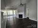 Bright living room features wood floors, fireplace, ceiling fan, and access to a sunroom through large glass doors at 5855 Amity Springs Dr, Charlotte, NC 28212