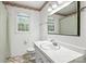 Bathroom with a sink, toilet, mirror, and floral wallpaper at 6319 Welford Rd, Charlotte, NC 28211