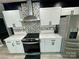 Stylish kitchen with white cabinets, stainless steel appliances, mosaic backsplash, and quartz countertops at 6490 Alta Ctr, Denver, NC 28037