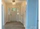 Bright entryway features a contemporary light fixture, grey door and wood look floors at 709 Falls Church Rd, Charlotte, NC 28270