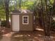 Outdoor storage shed with clean white door and window at 709 Falls Church Rd, Charlotte, NC 28270