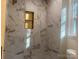 Shower with marble tile and a recessed shelf at 709 Falls Church Rd, Charlotte, NC 28270