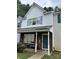 Traditional townhouse featuring brick accents, white siding and a covered front porch entrance at 7857 Petrea Ln, Charlotte, NC 28227