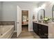 Open bathroom featuring a tub and double sink vanity with dark wood cabinets at 8524 Loxton Cir, Charlotte, NC 28214