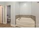 Clean bathroom featuring a soaking tub with tile surround at 8524 Loxton Cir, Charlotte, NC 28214
