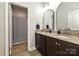 Bathroom with dual sinks, granite countertops, wood cabinets and a shower with patterned shower curtain at 8524 Loxton Cir, Charlotte, NC 28214