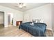 Bedroom features light gray walls, wood floors, a ceiling fan, and an entry to the bathroom at 8524 Loxton Cir, Charlotte, NC 28214