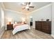 Comfortable bedroom with wood floors, two windows, and dark wooden dresser at 8524 Loxton Cir, Charlotte, NC 28214