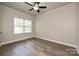 Bedroom features light gray walls, wood floors, a ceiling fan, and a window at 8524 Loxton Cir, Charlotte, NC 28214