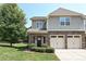 Charming townhome featuring a two-car garage, brick accents, and well-maintained landscaping at 8524 Loxton Cir, Charlotte, NC 28214