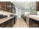 Bright kitchen featuring granite counters, dark wood cabinets, stainless steel appliances, and wood floors at 8524 Loxton Cir, Charlotte, NC 28214