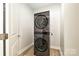 A compact laundry room featuring a stacked washer and dryer set at 8524 Loxton Cir, Charlotte, NC 28214
