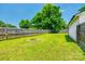 Large backyard with a well-maintained lawn, mature trees, wooden fence, and fire pit at 903 Rhode Island Ave, Kannapolis, NC 28083