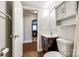 Bathroom featuring a vanity, sink, toilet, and storage cabinet, connected to a separate room at 903 Rhode Island Ave, Kannapolis, NC 28083