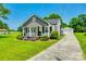 Charming home boasts a landscaped front yard and a detached garage with a long driveway on a sunny day at 903 Rhode Island Ave, Kannapolis, NC 28083