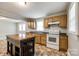View of the kitchen featuring wood cabinets, black countertops, a portable island, and white appliances at 903 Rhode Island Ave, Kannapolis, NC 28083