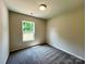 Cozy bedroom features neutral walls, plush carpeting, and a window with wooded views at 907 W Georgia Ave, Bessemer City, NC 28016