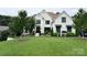 Charming white brick home with manicured lawn and garden, creating a welcoming curb appeal at 9604 Oliver Ct, Harrisburg, NC 28075