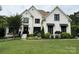 Stunning white brick home boasts lush landscaping, a manicured lawn, and black window accents at 9604 Oliver Ct, Harrisburg, NC 28075