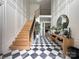 Grand foyer featuring a black and white checkered marble floor, staircase, and stylish decor at 9604 Oliver Ct, Harrisburg, NC 28075