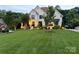 Stunning home with illuminated, professionally landscaped yard and elegant white brick exterior in a suburban setting at 9604 Oliver Ct, Harrisburg, NC 28075