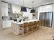 Bright and modern kitchen with a large island, pendant lighting, and stainless steel appliances at 9604 Oliver Ct, Harrisburg, NC 28075