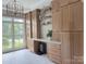 Custom wood cabinets provide ample storage in this laundry room with a herringbone-patterned tile floor and large window at 9604 Oliver Ct, Harrisburg, NC 28075
