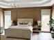 Luxurious main bedroom with tray ceilings, paneled walls, and coordinated bedside decor at 9604 Oliver Ct, Harrisburg, NC 28075